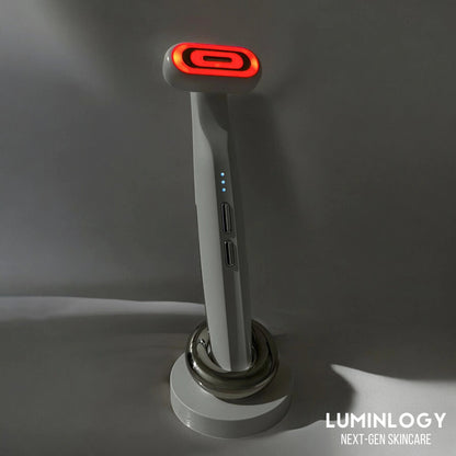 Red light therapy face beauty wand, standing on a charging dock showing its modern design.